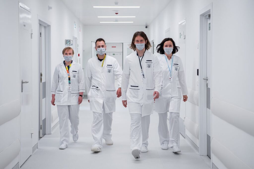 Medical team walking confidently in a hospital corridor, wearing face masks and white coats, symbolizing teamwork and healthcare dedication.